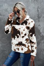 Cowhide sherpa quarter-zip pullover with brown and white pattern.