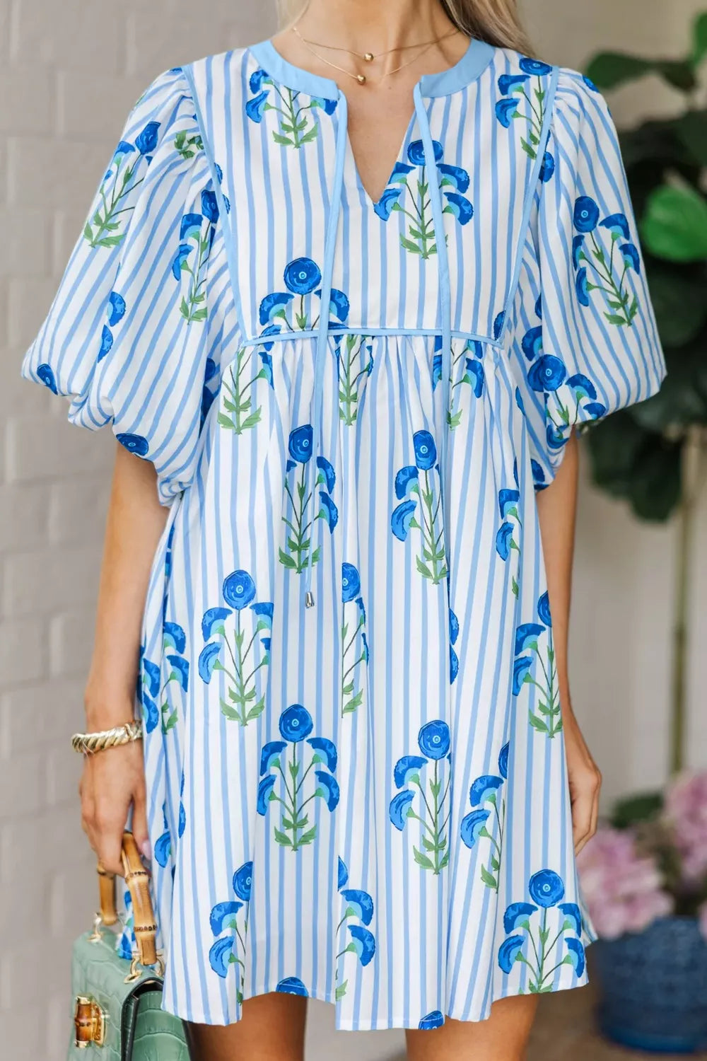 Floral stripe mini dress with puff sleeves and tie neck.