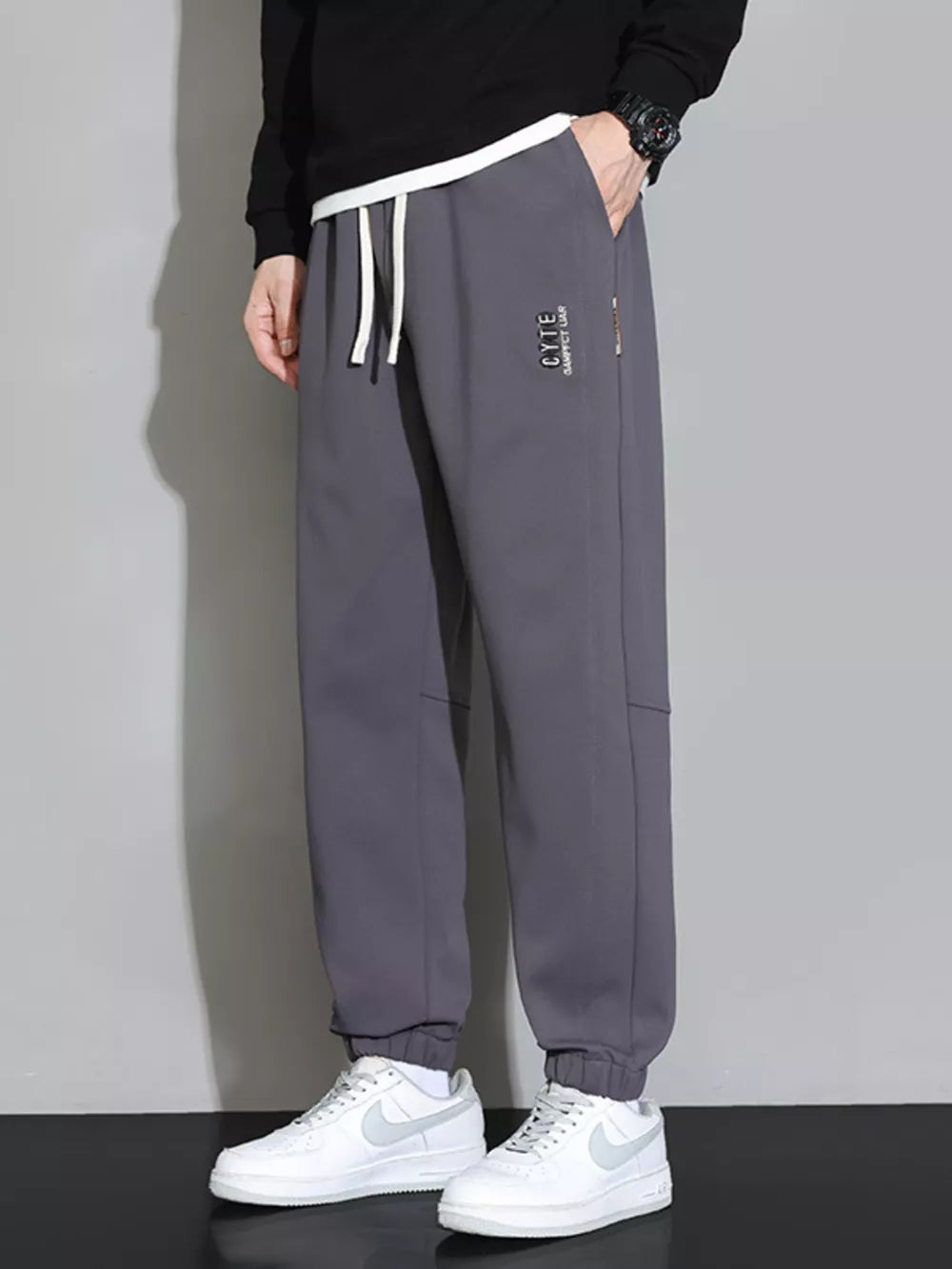 Grey men's jogger pants with cuffed ankles and drawstring waist.