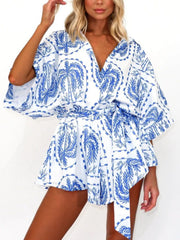 Blue celestial print wrap romper with short sleeves and tie waist
