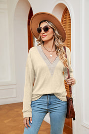 Pastel yellow relaxed knit sweater with lace-trimmed V-neck and long sleeves.
