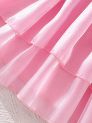 Pink baby dress with tiered ruffles and sheer organza fabric.