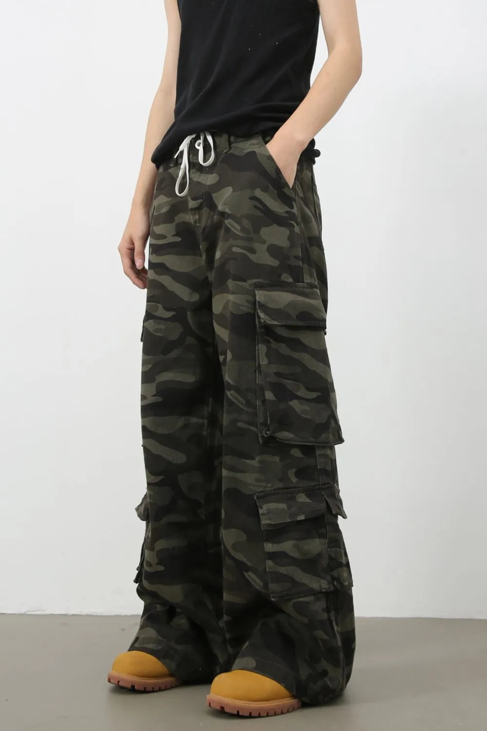 Wide-leg camo cargo pants with drawstring waist and multiple pockets.