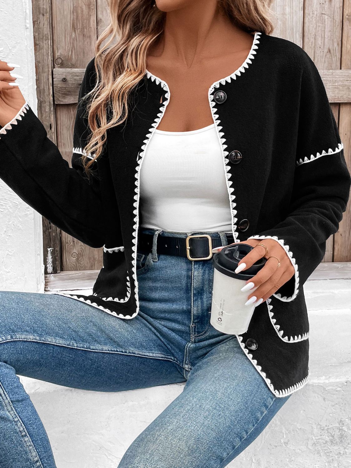 Black knit bolero jacket with white scalloped trim and button front.