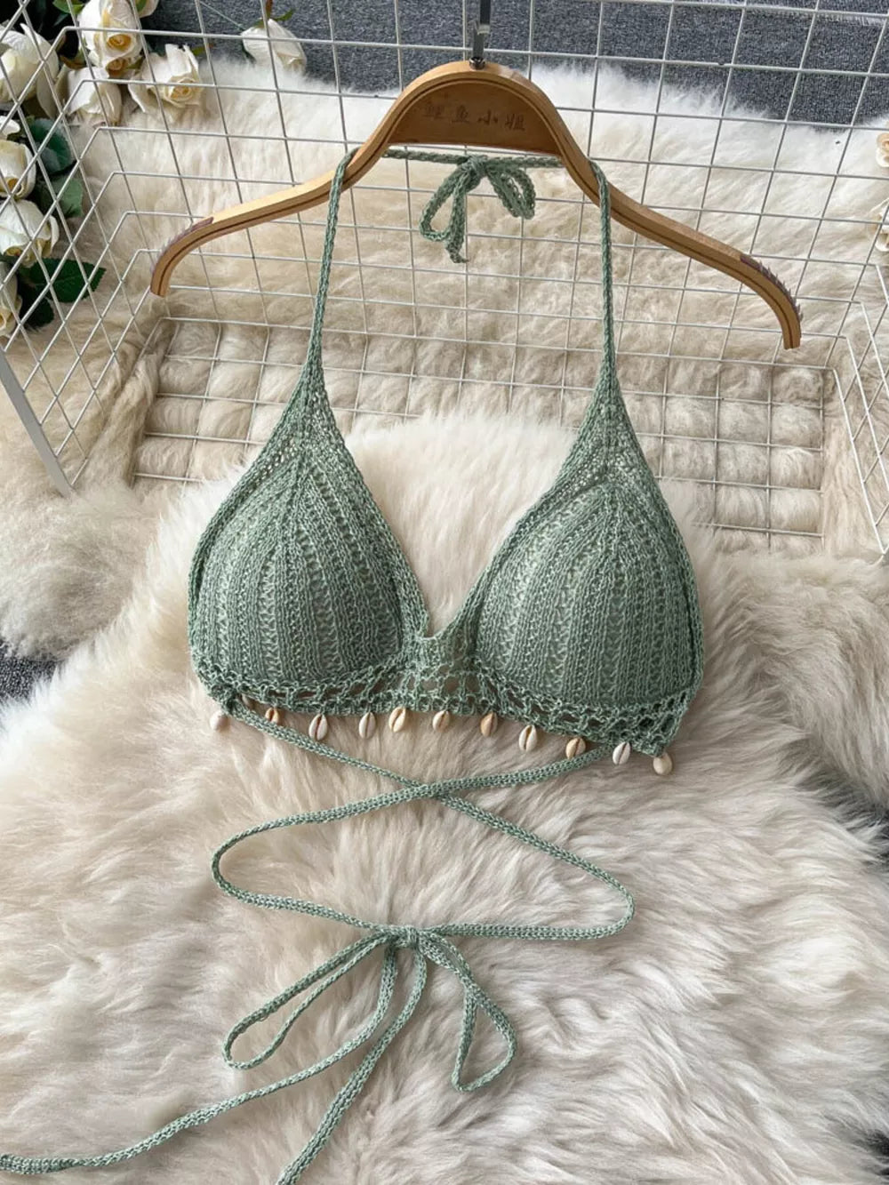 Green crochet halter bikini top with shell trim and tie closure.