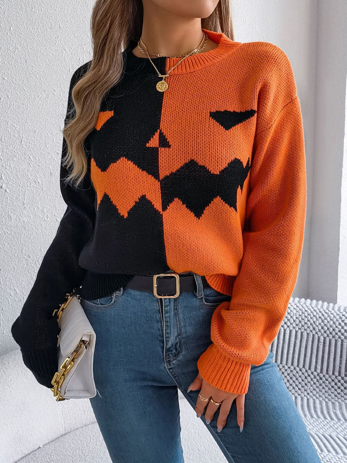 Split-face pumpkin knit sweater in orange and black acrylic with crewneck and long sleeves.