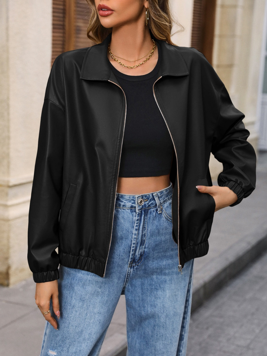 Black faux leather bomber jacket with zip front and elastic cuffs.