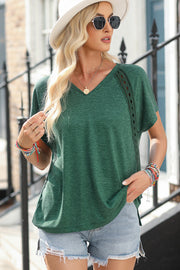 Dark green dolman sleeve tunic with lace insets and V-neck.