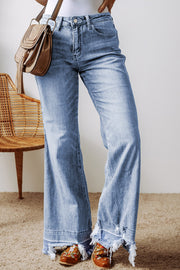 Medium wash denim flare jeans with raw hem detail.