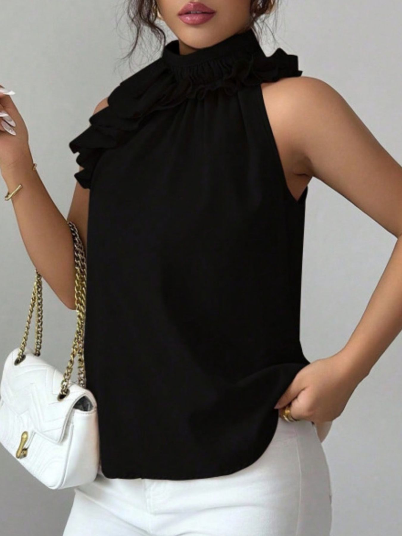 Black ruffled high neck sleeveless blouse with a casual cut.