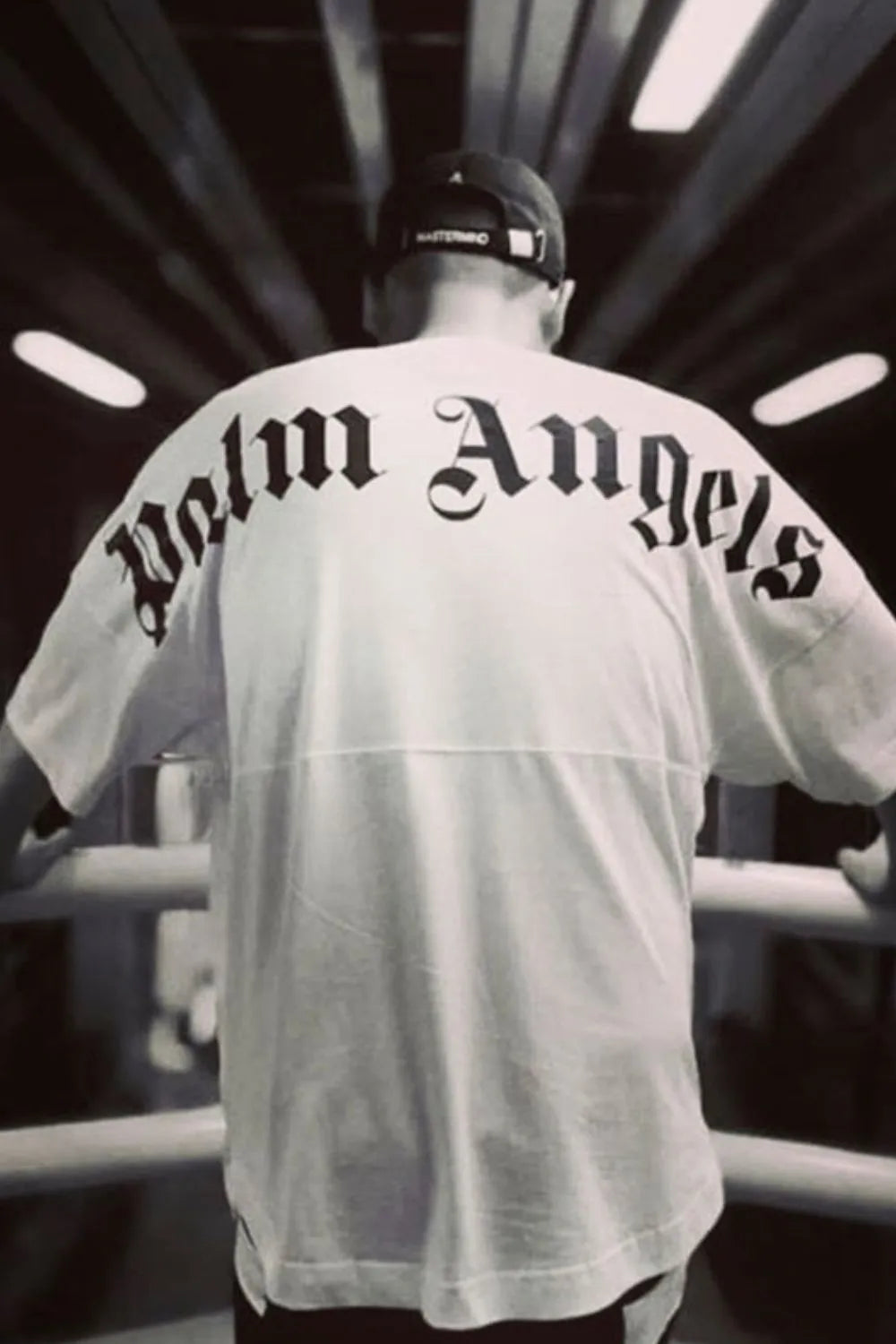 White oversized tee with black gothic logo print on back