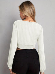 Textured wrap-front crop top in light gray with long sleeves and a ribbed hem.