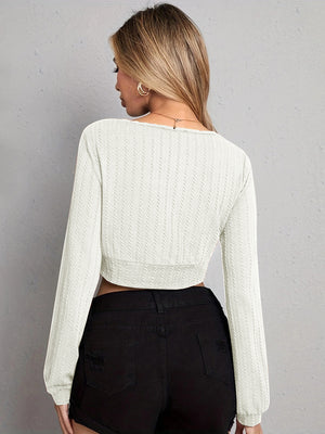 Textured wrap-front crop top in light gray with long sleeves and a ribbed hem.