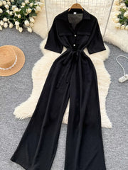 Black belted wide-leg maternity jumpsuit with pockets and button details.