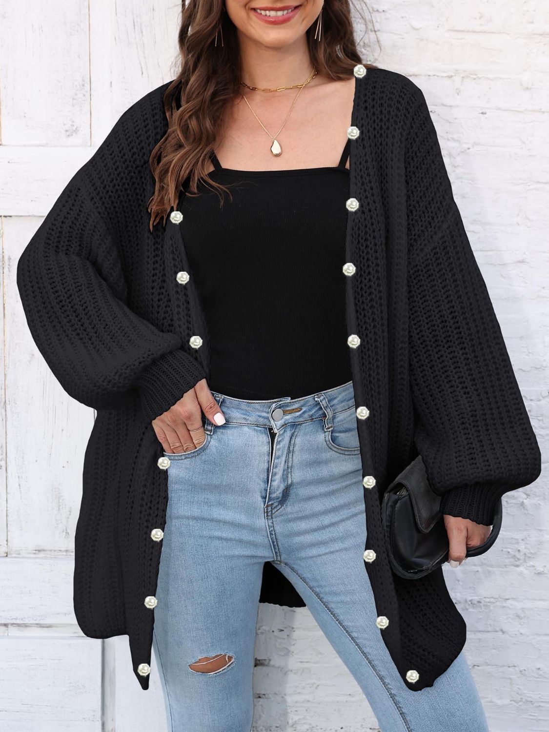 Black balloon sleeve cardigan with pearl buttons and open knit detail.