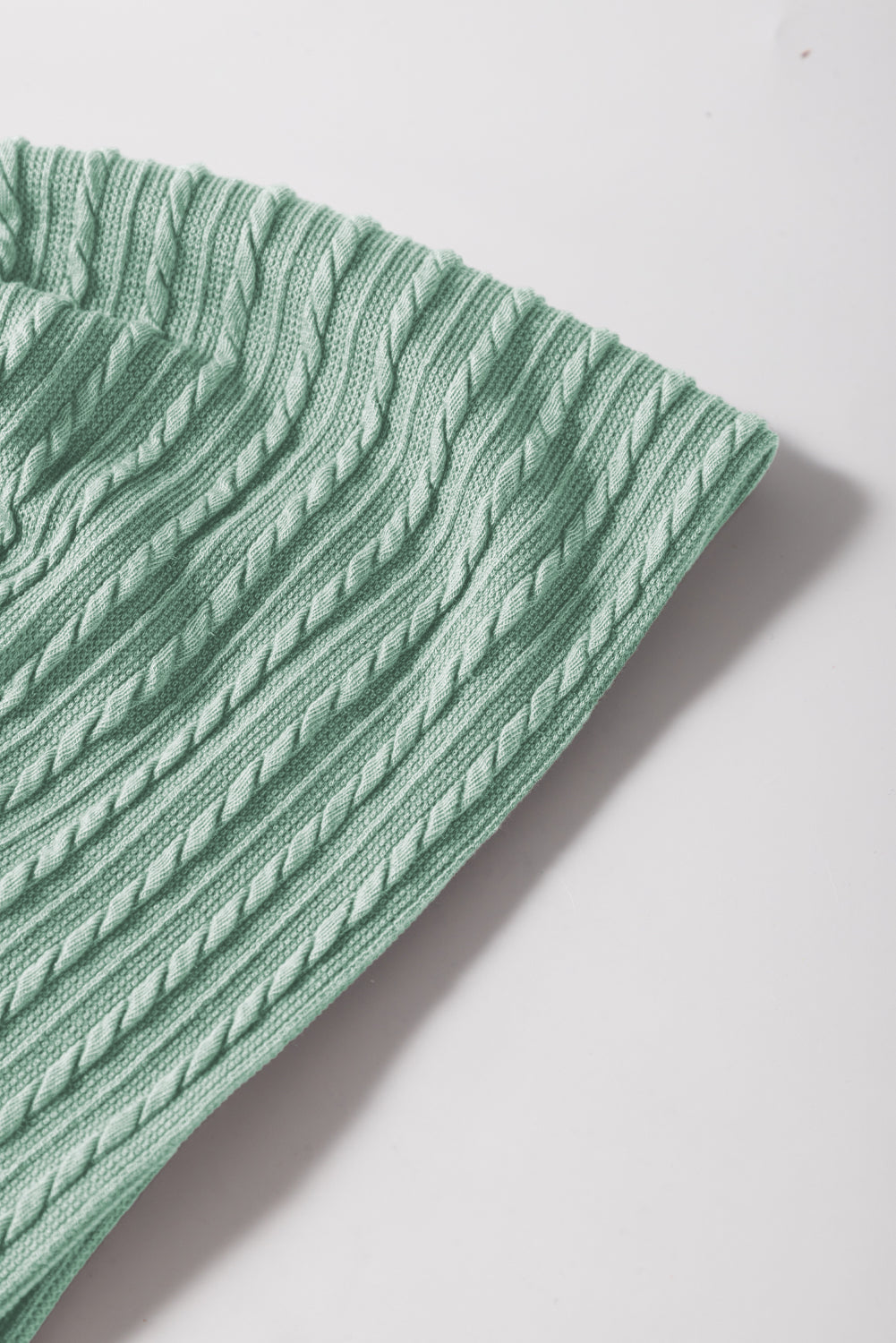 Textured cable knit sweater in Gum Leaf green with flutter sleeves.