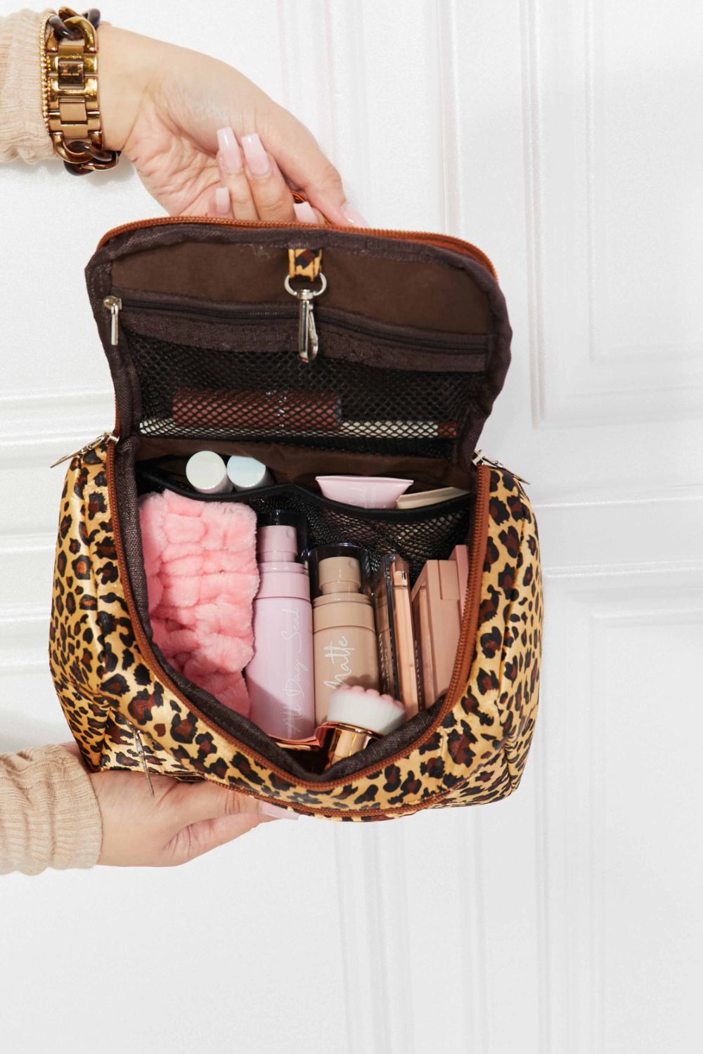 Leopard print travel organizer bag with makeup and toiletries inside