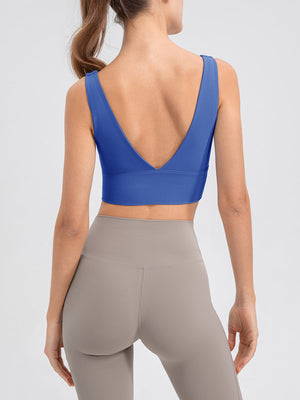 Blue performance crop top with deep V-back and wide band detail.