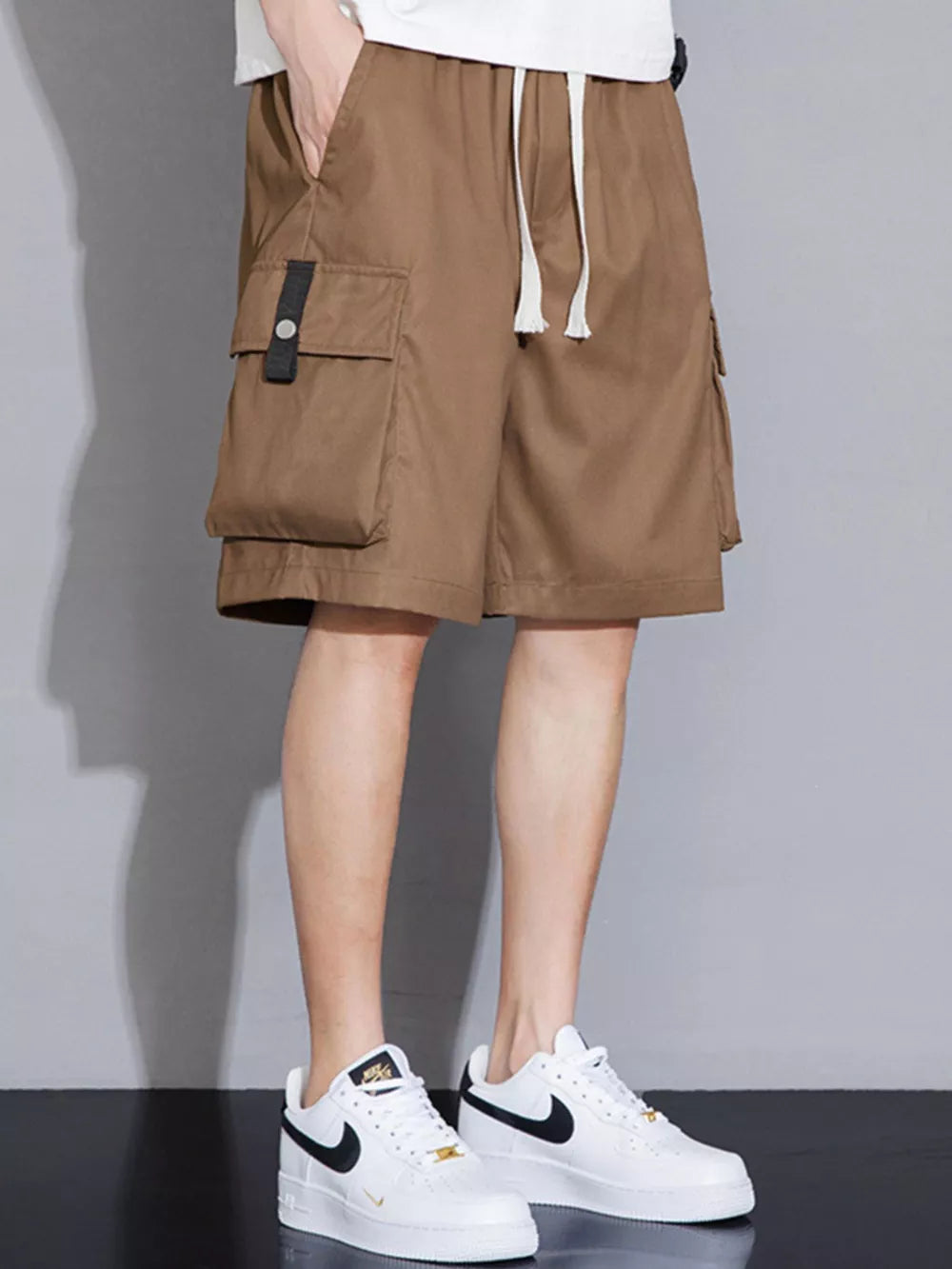 Brown cargo shorts with drawstring waist and multiple pockets.