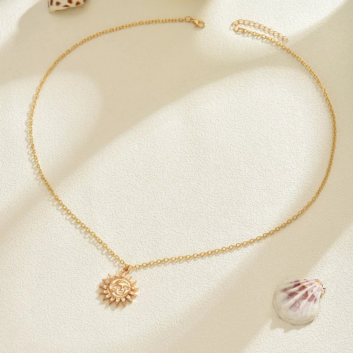 Gold sunburst pendant necklace with a delicate chain, bohemian style.