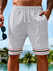 Gray textured knit drawstring shorts with striped cuffs and pockets.