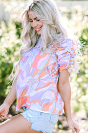 Multicolor psychedelic print smocked blouse with puff sleeves and ruffled cuffs.