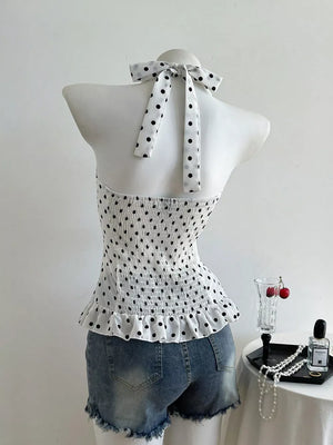 White polka dot halter cami with smocked bodice and ruffled hem.