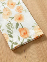 Baby floral print pants with orange roses and green leaves on white cotton.