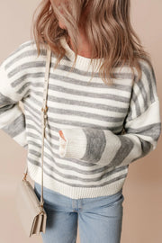 Relaxed knit sweater with wide grey and white stripes, crewneck, and long sleeves.