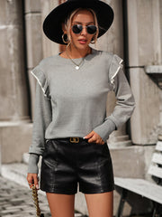 Light gray crew neck sweater with contrast trim ruffle shoulders and ribbed cuffs.