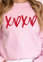 Blush pink sweatshirt with red XOXO graphic print, relaxed fit, crew neck.