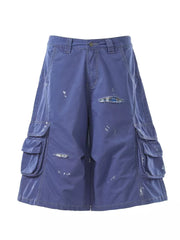 Blue distressed cargo capris with multiple pockets and plaid patch detail.