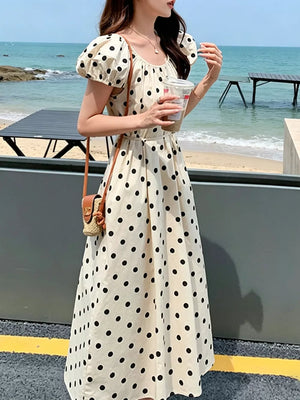 Cream polka dot midi dress with puff sleeves and scoop neckline.