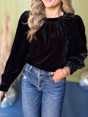 Black velvet ruched blouse with long puff sleeves and a high neckline.