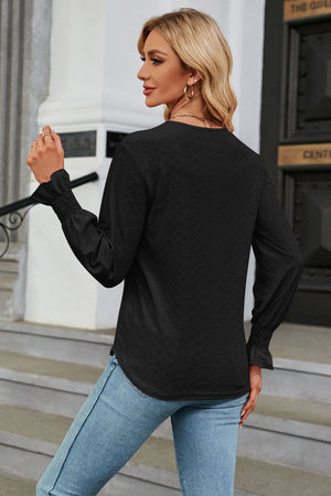 Black textured V-neck blouse with smocked cuffs and long sleeves