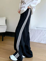 Black maternity joggers with white side stripes and wide legs.