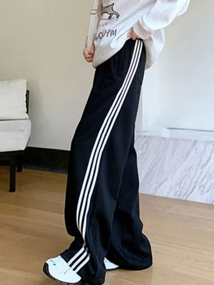 Black maternity joggers with white side stripes and wide legs.