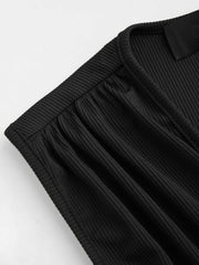 Black ribbed plunge romper with gathered detail at the neckline.