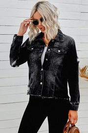 Black distressed denim trucker jacket with frayed hem and distressed details.