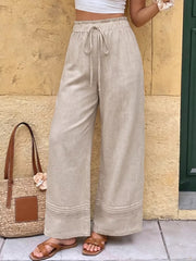 Beige wide-leg maternity trousers with drawstring waist and lace trim detail.