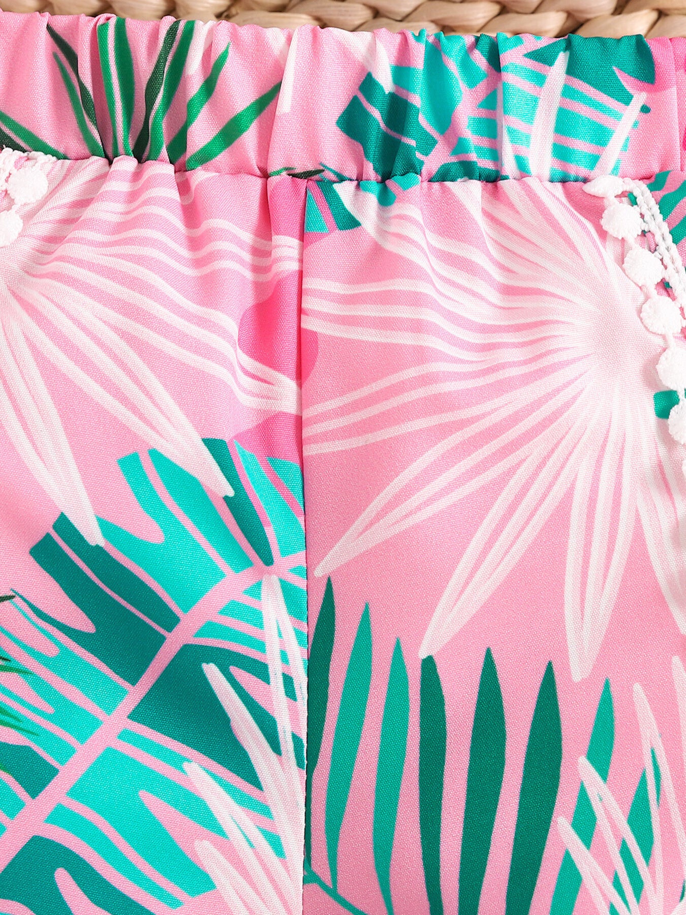 Pink floral print baby shorts with elasticated waist and pom-pom trim.
