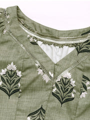 Botanical print V-neck blouse in matcha green with decorative trim and a textured fabric.