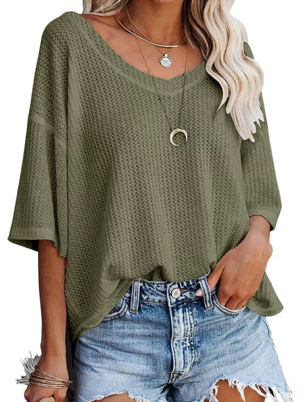 Olive green waffle knit relaxed v-neck t-shirt with short sleeves, styled with necklaces and denim shorts.