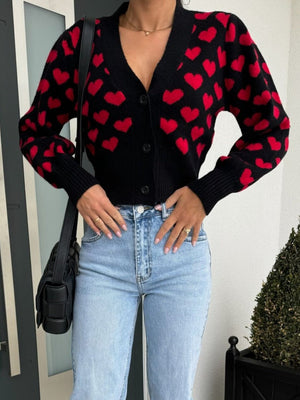 Black knit cardigan with red hearts, puff sleeves, and button front.
