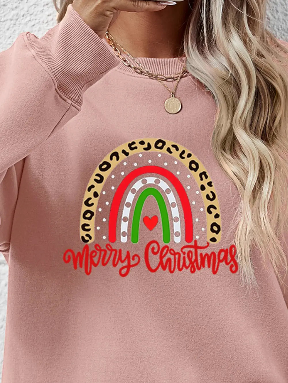 Blush pink sweatshirt with rainbow graphic and Merry Christmas text.