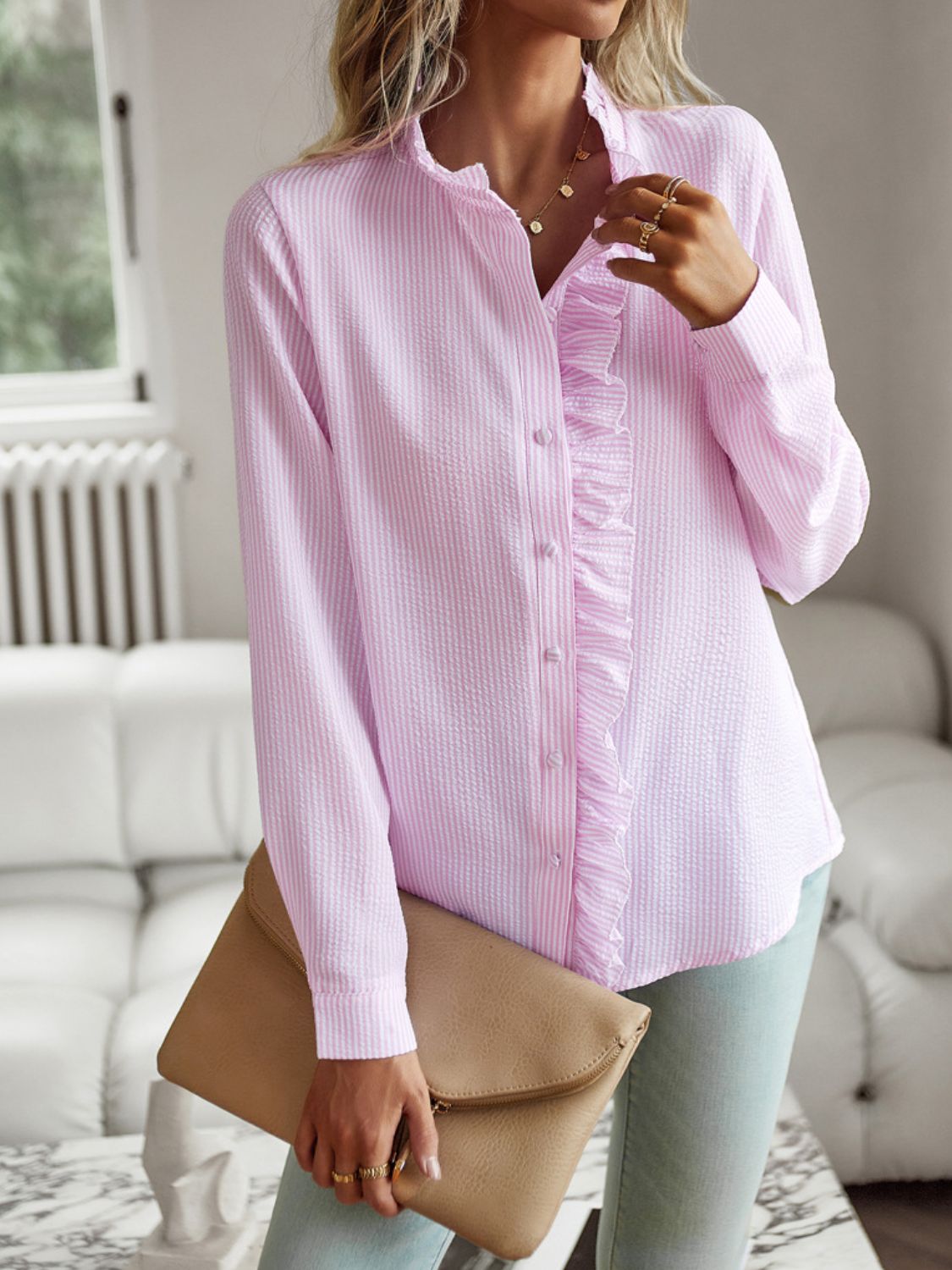 Blush pink striped blouse with ruffle trim and button front, long sleeves.