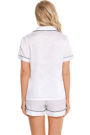 White satin pajama set with black piping, short sleeves and shorts