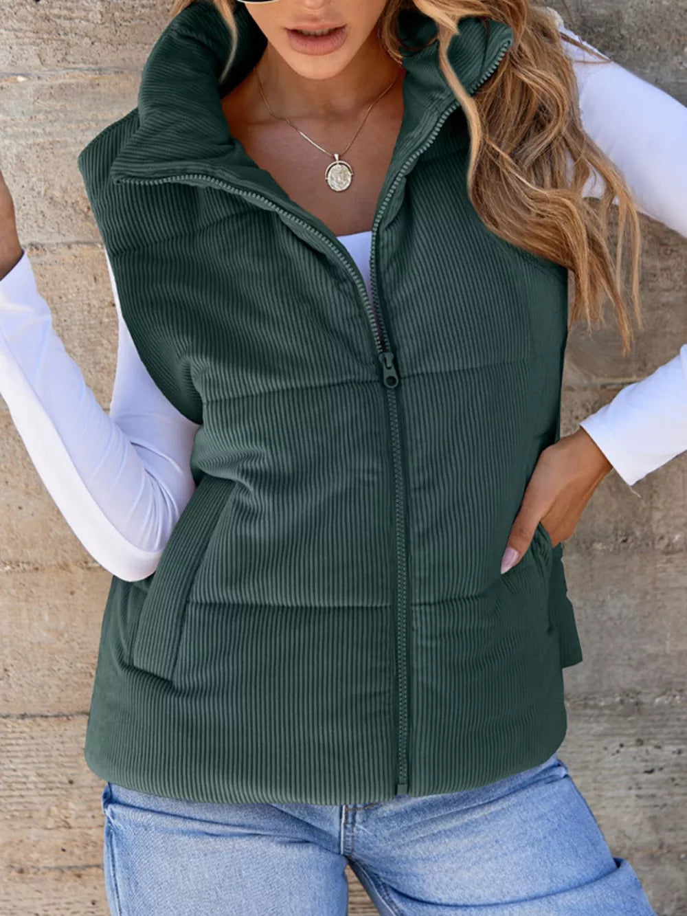 Green ribbed corduroy zip-up vest coat with stand-up collar and pockets.