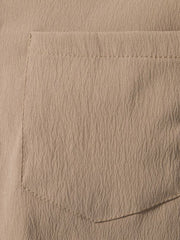 Men's plus-size beige cotton button-up shirt with textured fabric and chest pocket.
