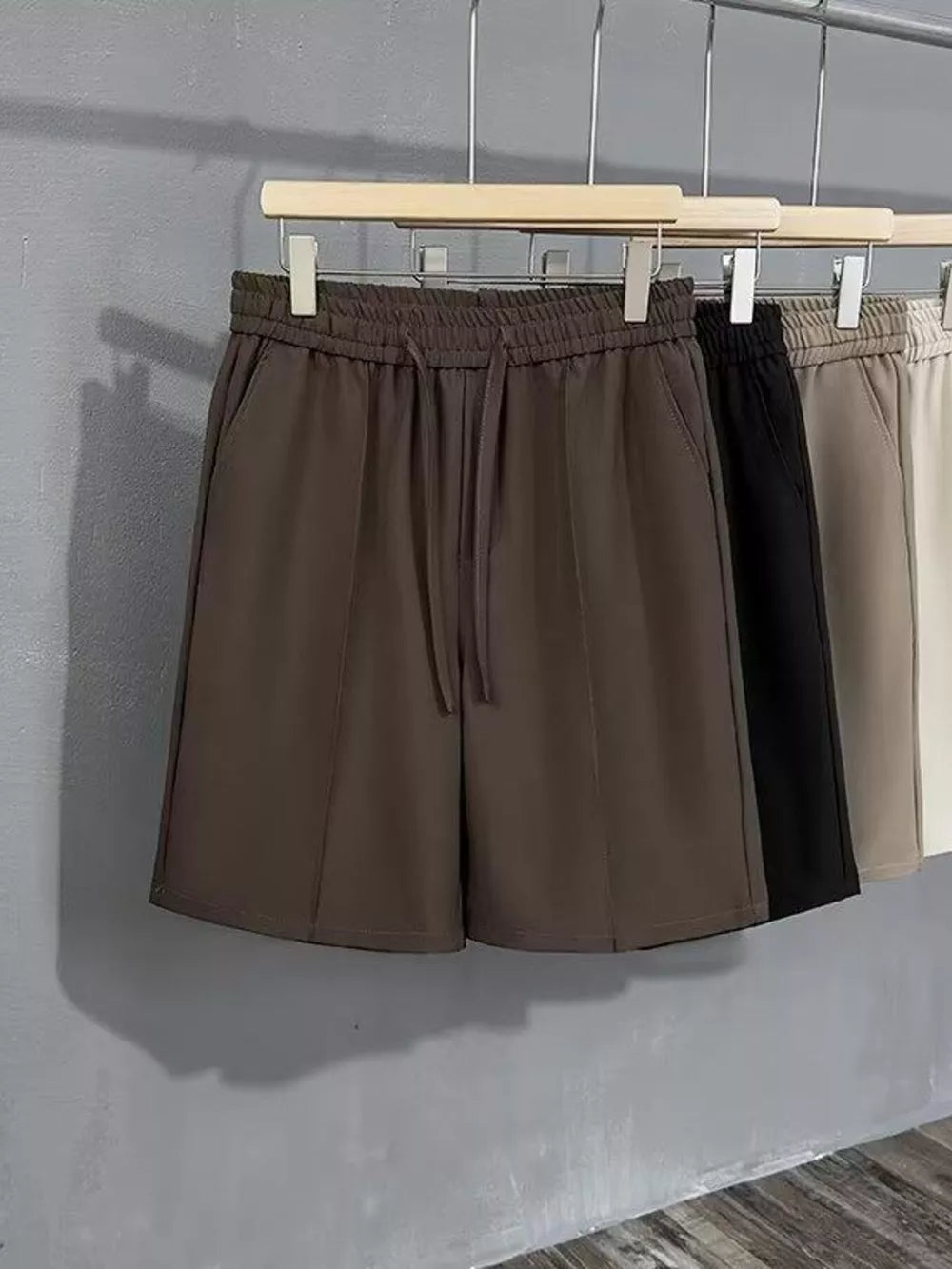 Brown cotton chino shorts with drawstring waist and pleated front detail.
